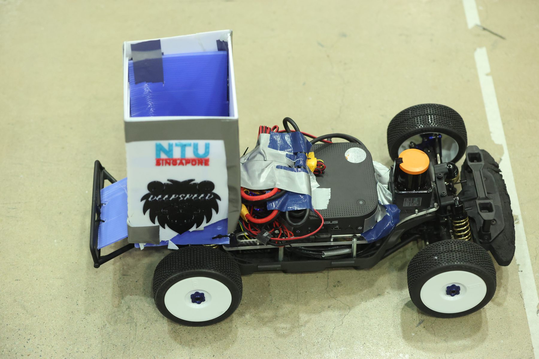 Top-down view of the rebuilt car showing the Intel NUC, servos and wiring under the body shell