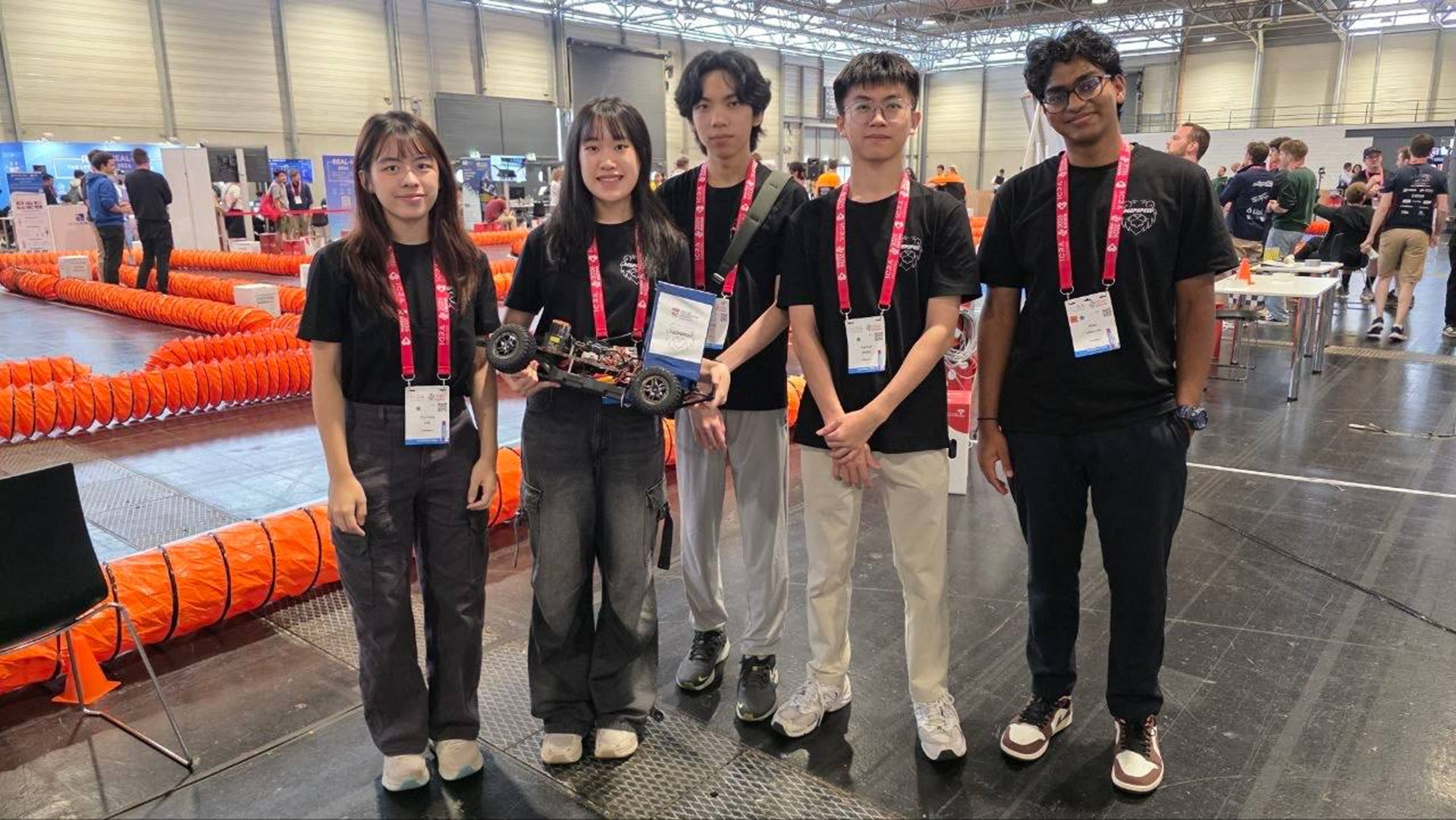 The NTU DeepSpeed ICRA crew holding the car beside the track in Vienna